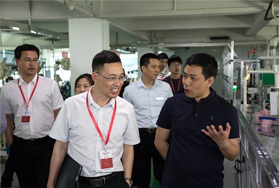 欣靈公司總裁張彭春（右一）陪同市委領(lǐng)導參觀車間